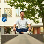 man in white dress shirt sitting on gray concrete bench during daytime