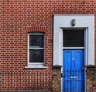 red brick building with closed door and window