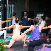 woman in white tank top and pink leggings doing yoga