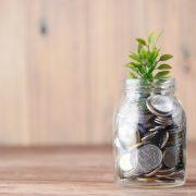 a glass jar filled with coins and a plant