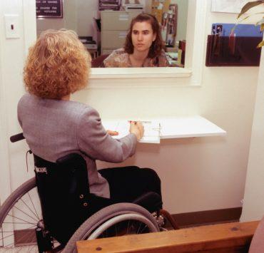 a woman sitting in a wheel chair in front of a mirror