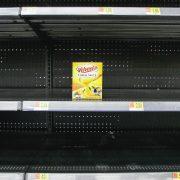 empty shelves in a grocery store with a box of yogurt