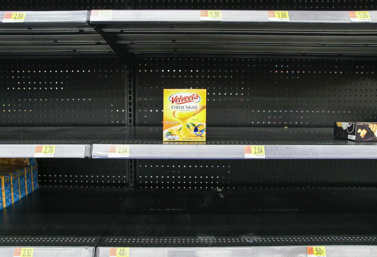 empty shelves in a grocery store with a box of yogurt