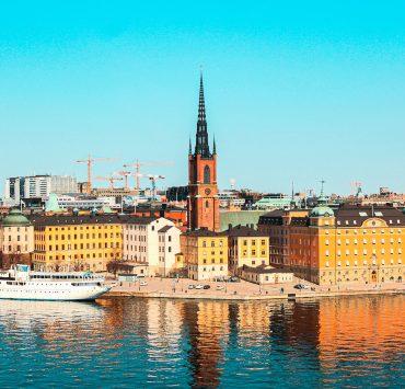 white boat on water near city buildings during daytime