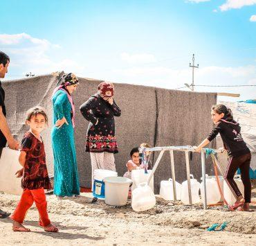 a group of people standing on top of a sandy beach