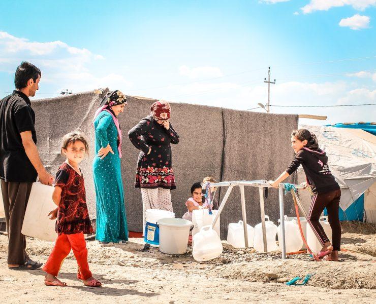 a group of people standing on top of a sandy beach