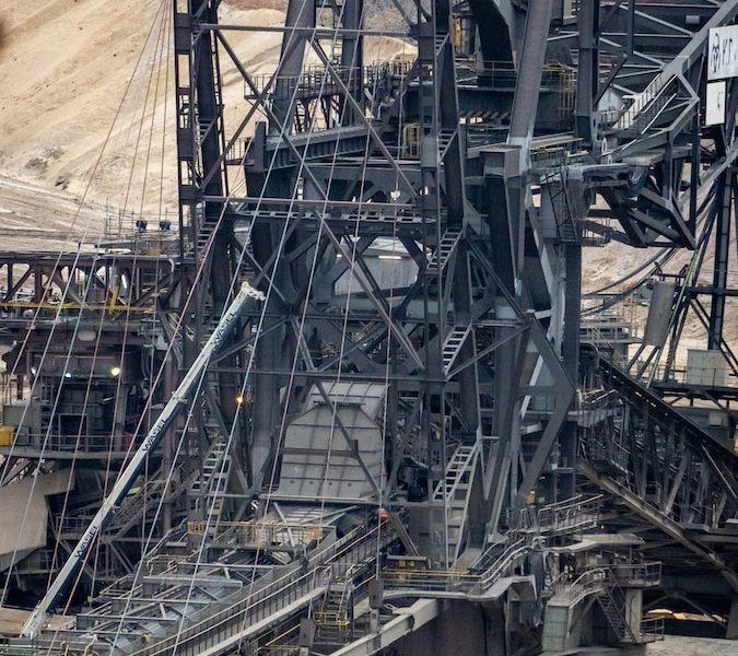 there is a large crane that is in the dirt