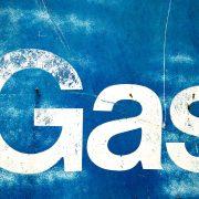 the word gas painted on the side of a blue wall