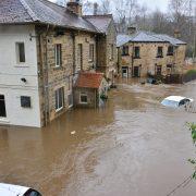 brown and white concrete house beside river during daytime