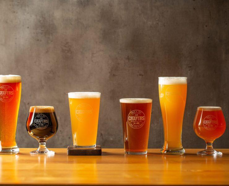 three clear drinking glasses on brown wooden table