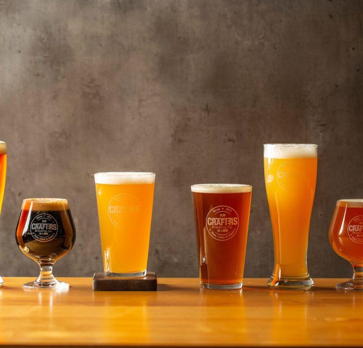 three clear drinking glasses on brown wooden table