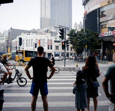 man in black t-shirt and blue shorts standing on pedestrian lane during daytime