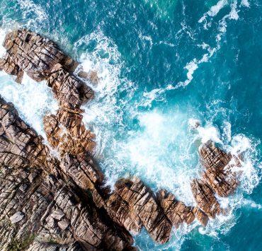 rock mountain next to ocean water