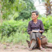 man in blue and white long sleeve shirt sitting on brown log during daytime