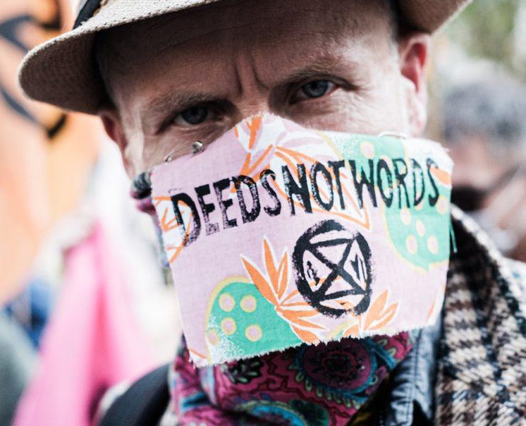 man in brown hat with yellow blue and red scarf