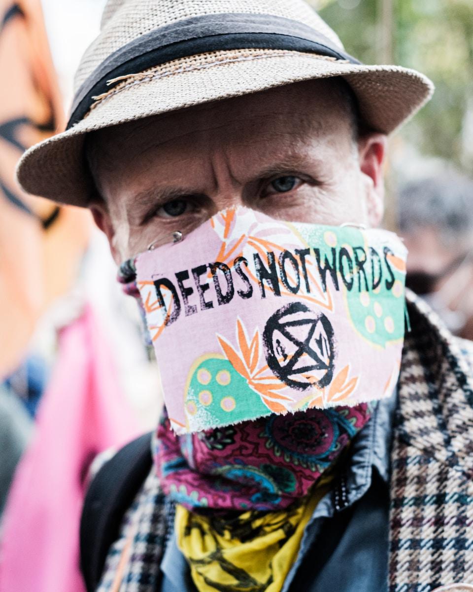 man in brown hat with yellow blue and red scarf
