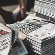 shallow focus photography of piles of newspapers