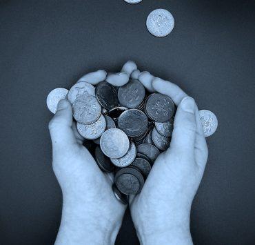 a person holding a bunch of coins in their hands