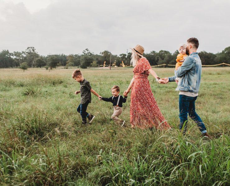 woman holding man and toddler hands during daytime