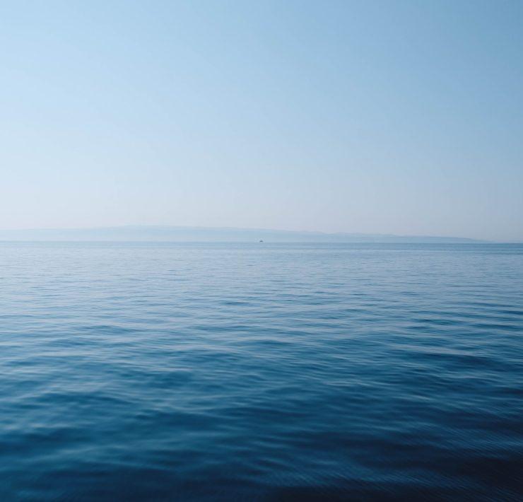 body of water under blue and white sky at daytime