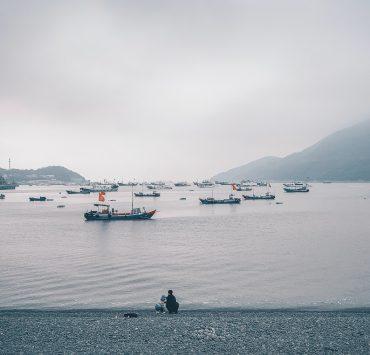 boats on body of water under cloudy sky