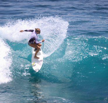 woman in black bikini surfing on sea waves during daytime