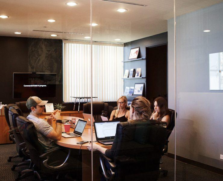 people sitting near table with laptop computer