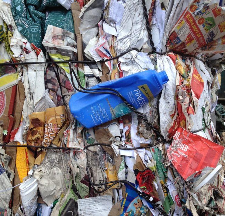 blue plastic bottle on top of garbage