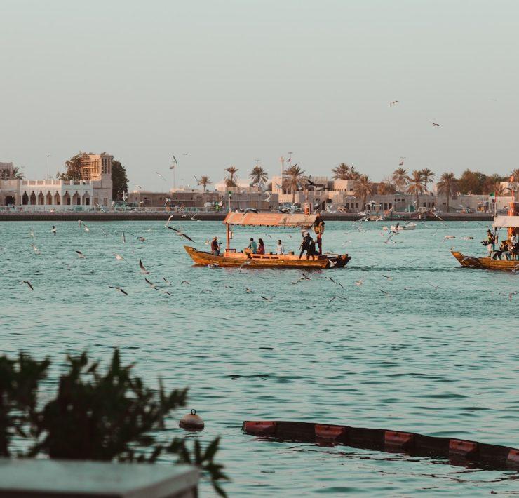 people on boat near buildings at daytime