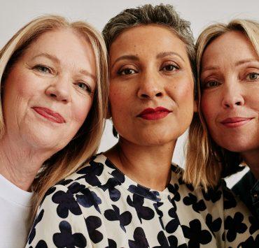a group of three women standing next to each other