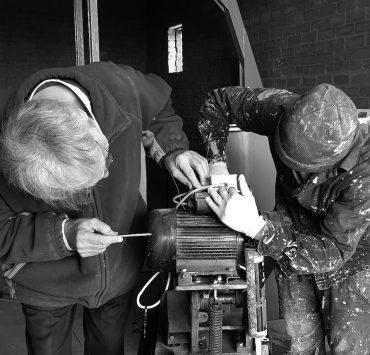 two person fixing AC motor