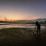 a couple of people standing on top of a beach