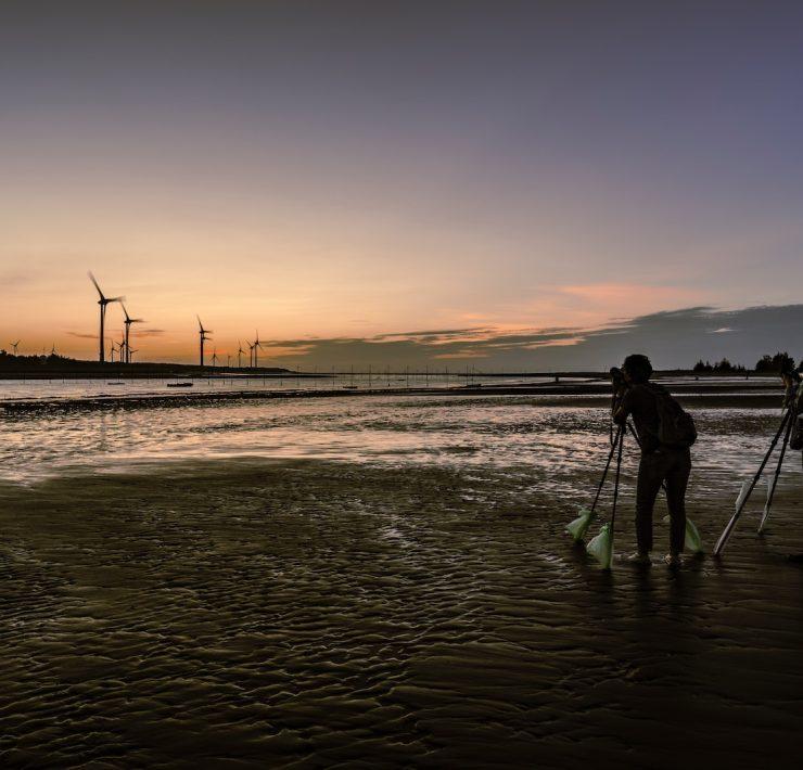 a couple of people standing on top of a beach