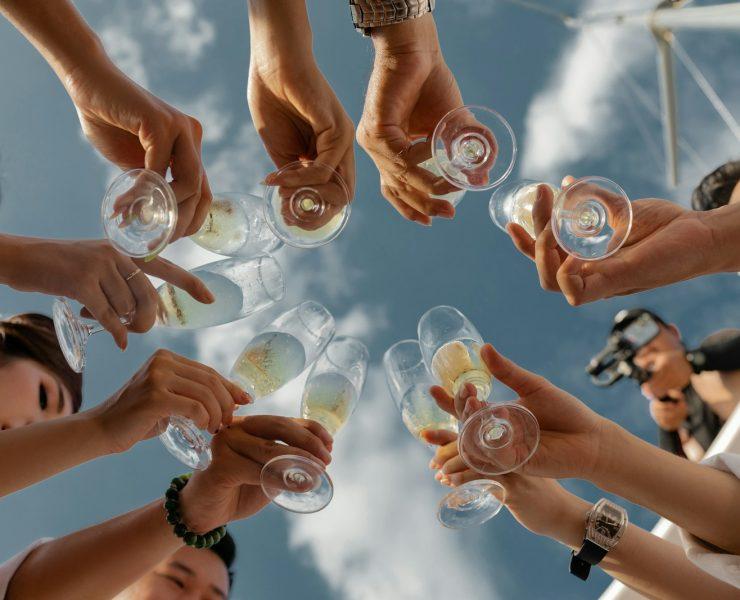people holding clear glass bottles during daytime