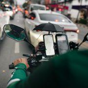 a man riding a motorcycle down a street next to traffic