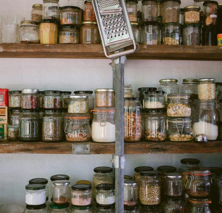 assorted glass jars on white wooden shelf