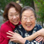 An Elderly and a Mature Woman Embracing and Smiling