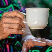 person holding white ceramic teacup