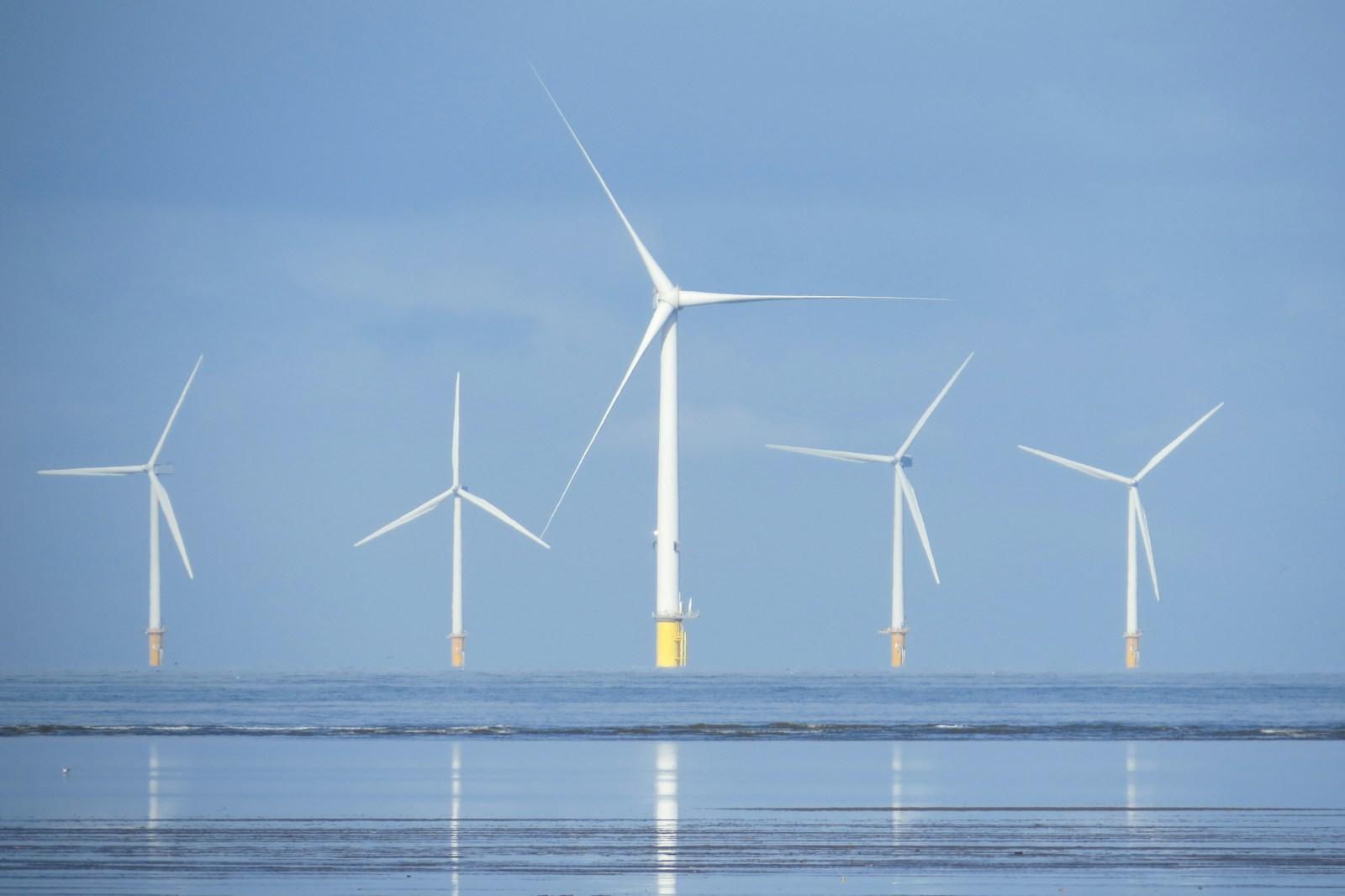 a group of wind turbines in the ocean