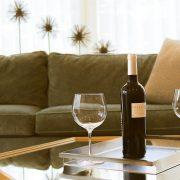 black wine bottle beside two wine glasses