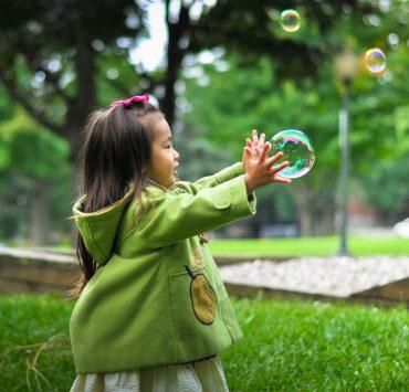 selective photo of a girl holding bubbles