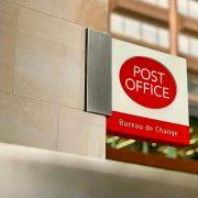 a post office sign on the side of a building