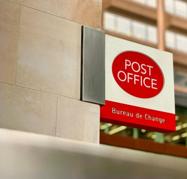 a post office sign on the side of a building
