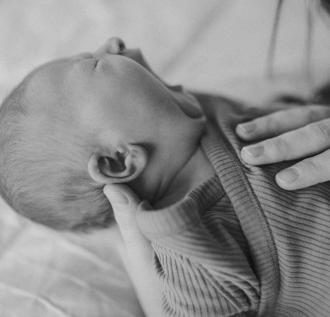 a black and white photo of a woman holding a baby