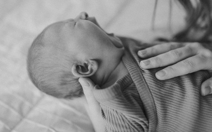 a black and white photo of a woman holding a baby