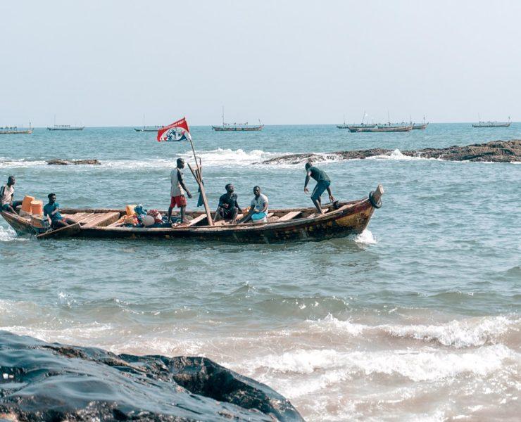 people riding boat at the ocean during day